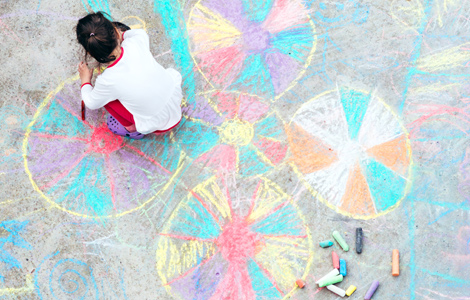 young child making chalk drawings